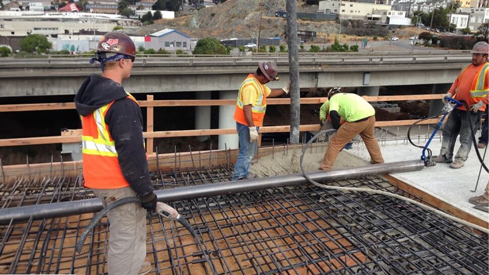 Construction workers repairing a concrete bridge pylon