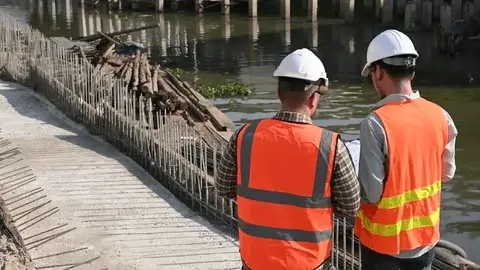 Team of engineers discussing bridge schematics