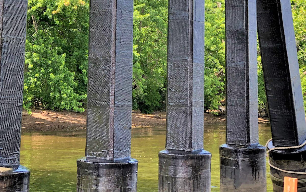 Workers applying carbon fiber wrap to a bridge column